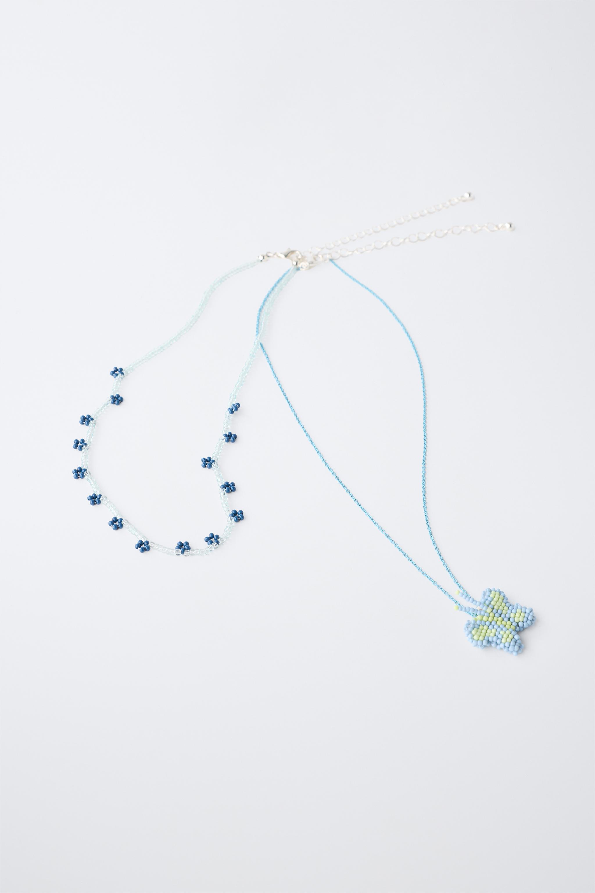 LOT DE DEUX COLLIERS FANTAISIE PAPILLON ET FLEURS